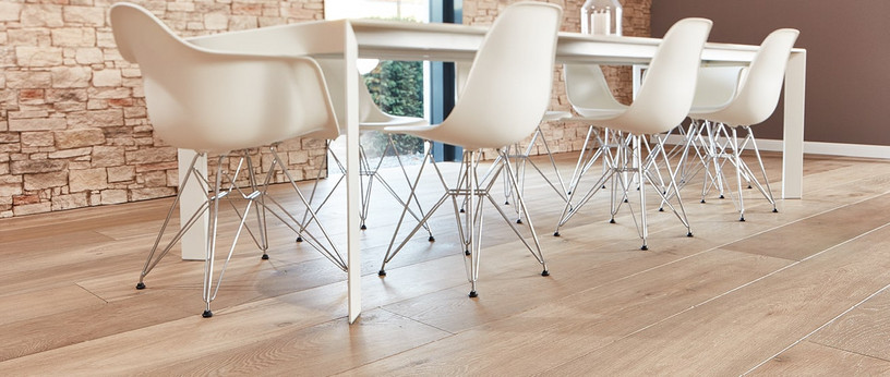 Tisch mit modernen Stühlen auf Parkett im Format Landhausdiele